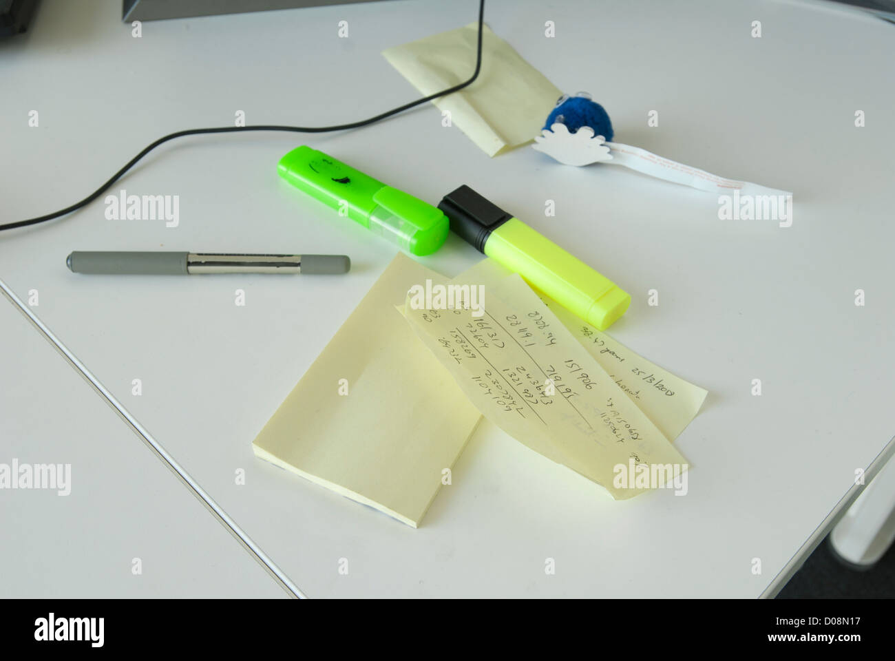 Pens, highlighter and post it notes on white desk in office Stock Photo