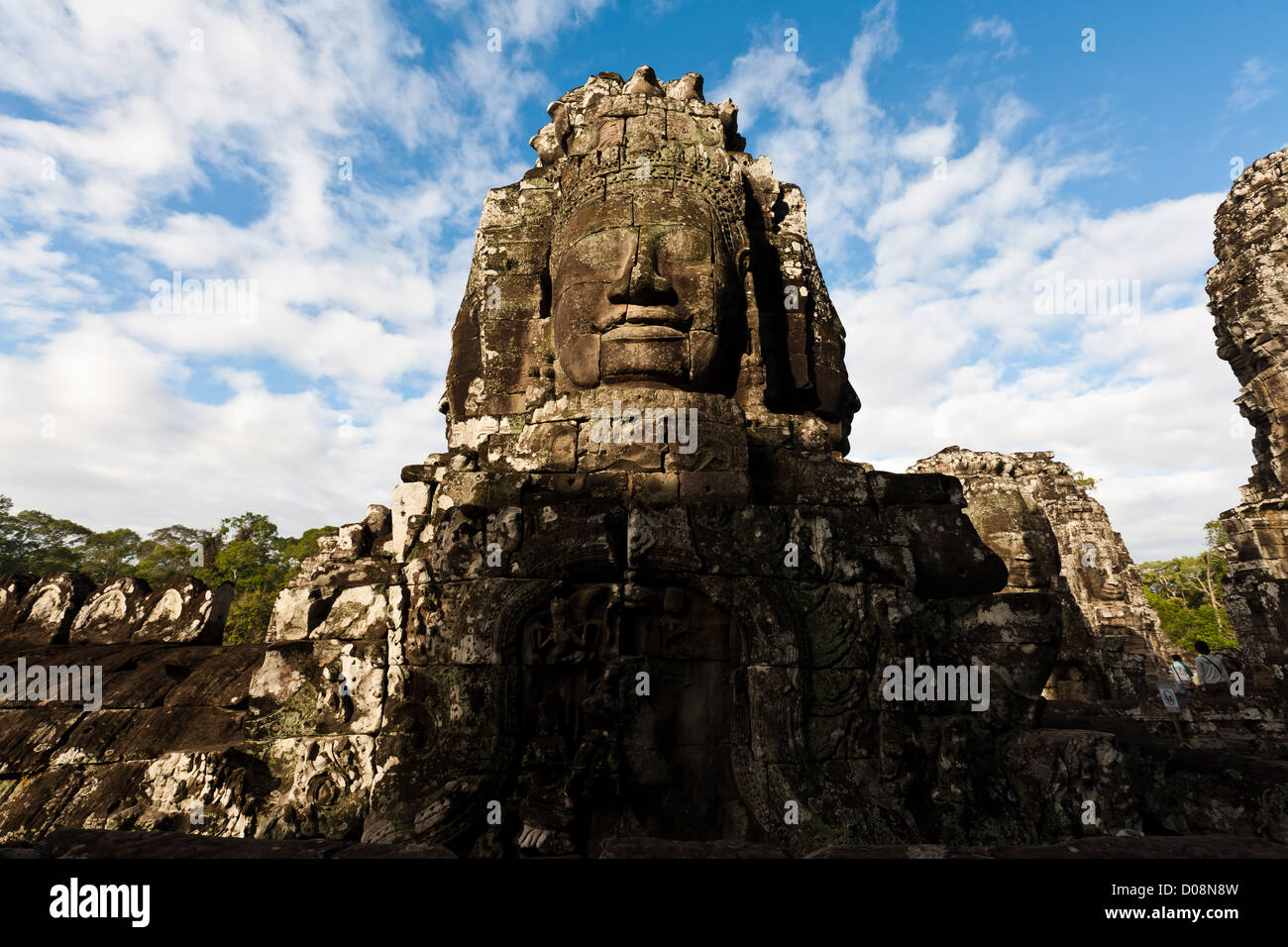 Famous carved stone head statue of ancient Prasat Bayon temple in UNESCO World Heritage SIte at Angkor Wat, SIEM REAP, CAMBODIA Stock Photo