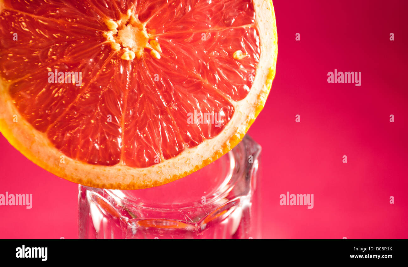 Grapefruit on top of glass with pink background Stock Photo Alamy