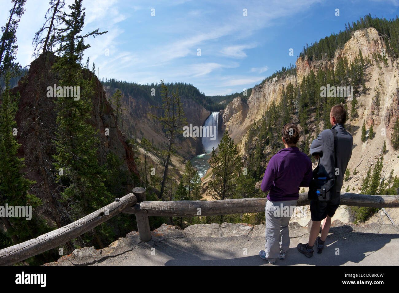 Young couple admiring the view of Lower Falls from Red Rock Point, Grand Canyon of the Yellowstone River, Yellowstone NP USA Stock Photo