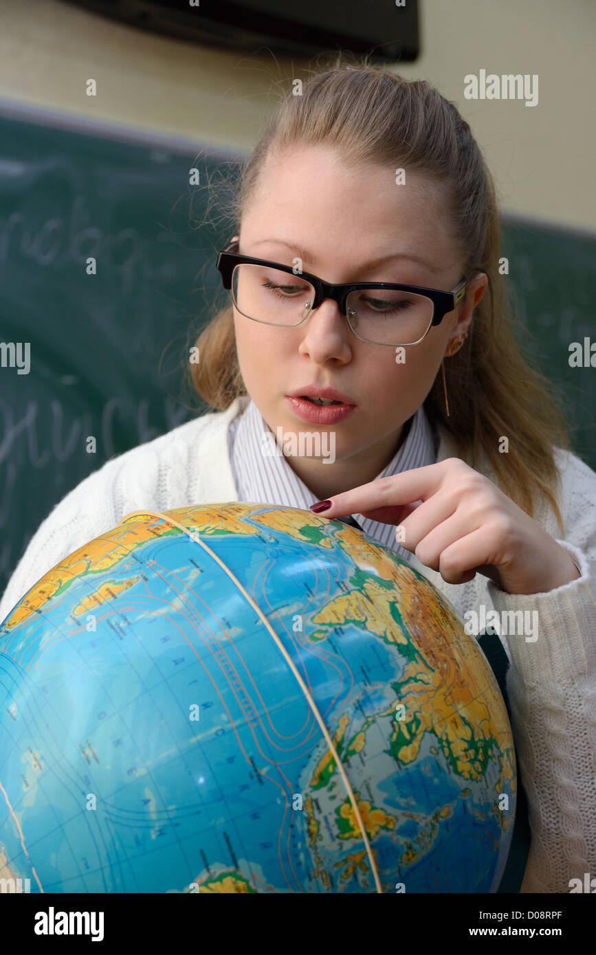 Woman examining a globe Stock Photo