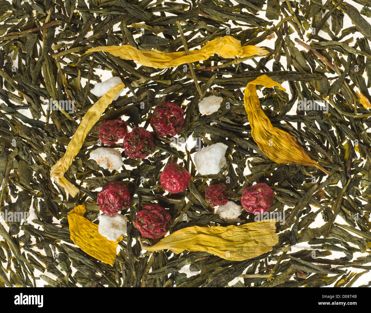Background image consisting of tea leaves and dry fruits with focus on berries Stock Photo