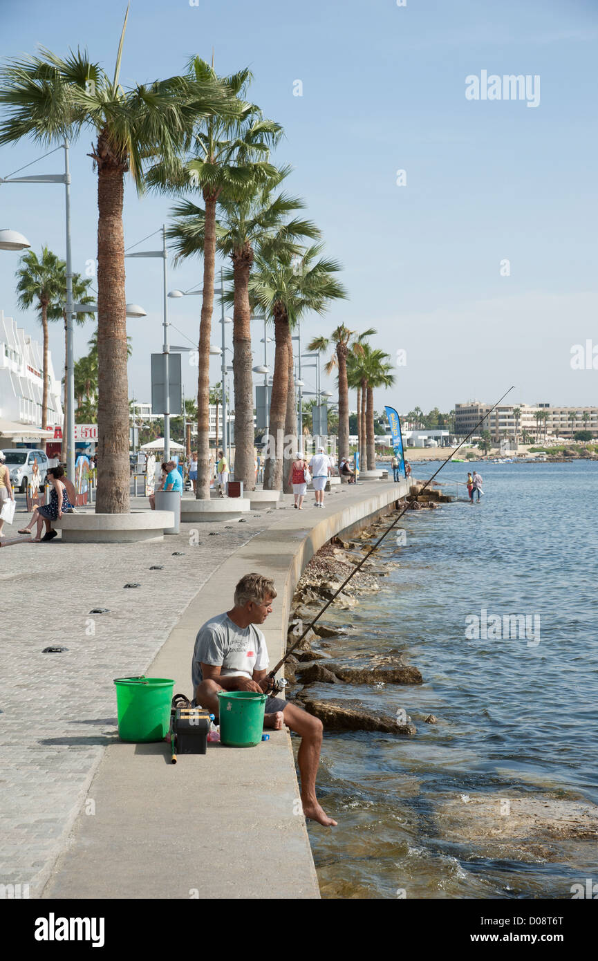 Waterfront in Paphos Cyprus Man fishing from the sea wall Stock Photo