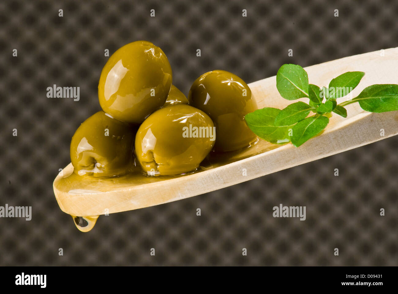 Several olives on wooden spoon over extra virgin oil Stock Photo - Alamy