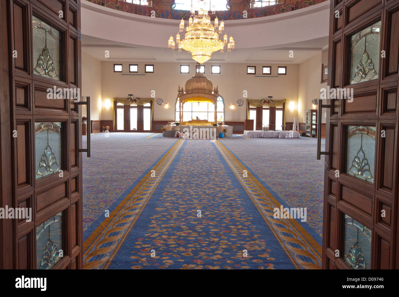 A Sikh Gurdwara Darbar Sahib looking towards the Manji Sahib with a Granthi reading the Guru Granth Sahib Stock Photo