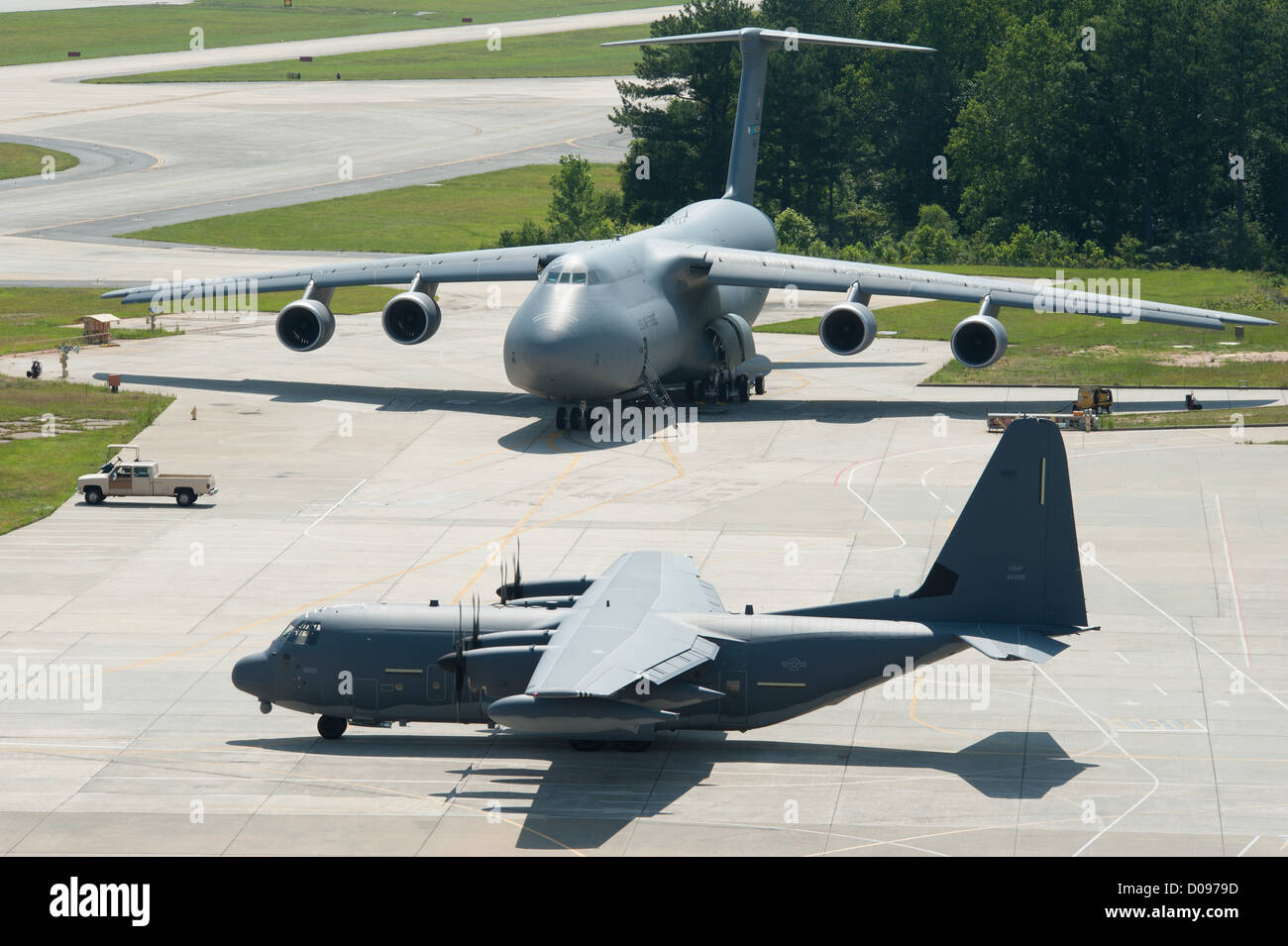 A C-5M Super Galaxy “looks on” as Lockheed Martin delivered its seventh MC-130J Commando II to Cannon Air Force Base, N.M., on June 20, 2012. The Super Galaxy is slated to be delivered this summer to Dover Air Force Base, Del. Both aircraft have set the Air Force standards in tactical and strategic airlift. Stock Photo