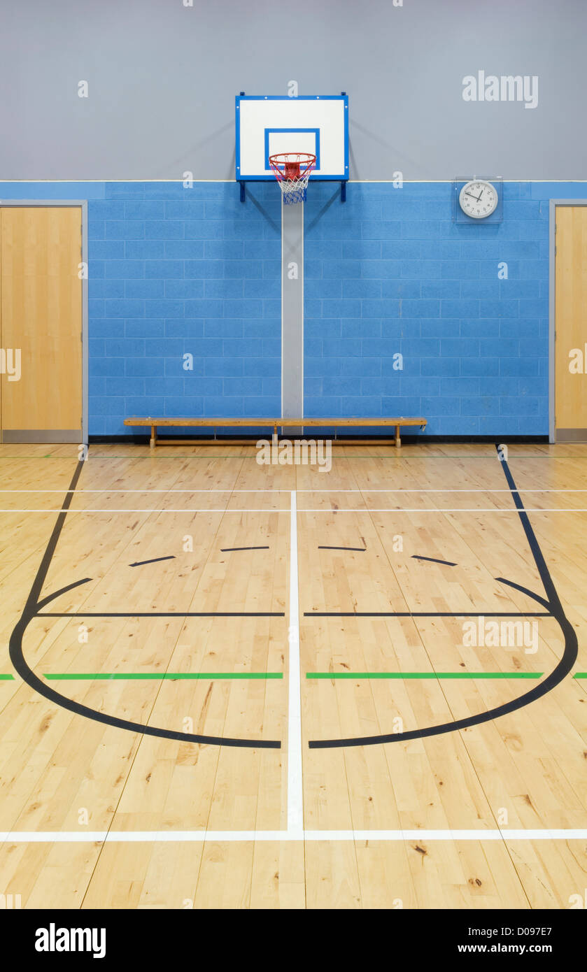 Basketball court markings and hoop in the sports hall of a modern secondary school. Stock Photo