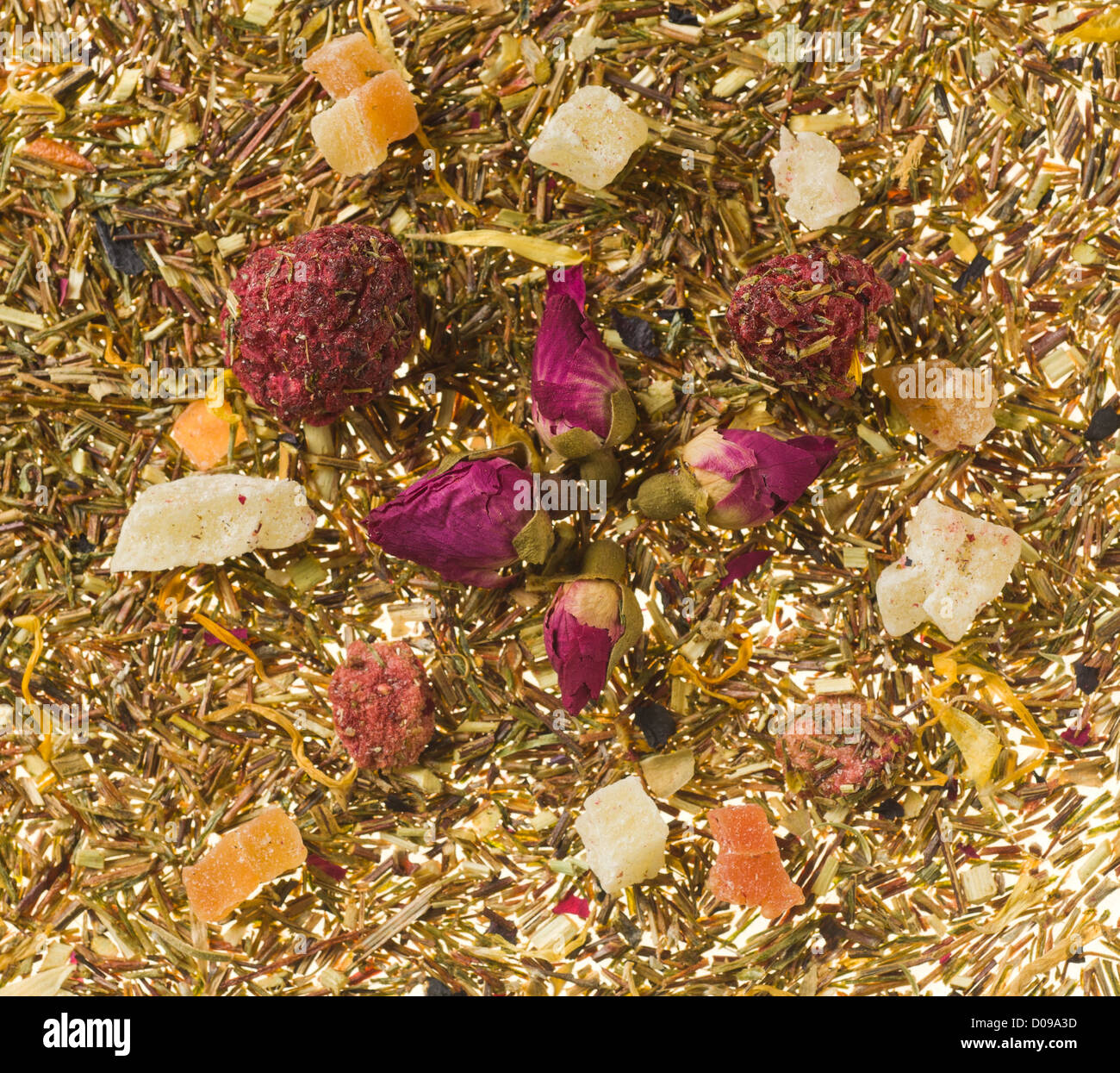 Background image consisting of tea leaves and dry fruits with focus on berries Stock Photo