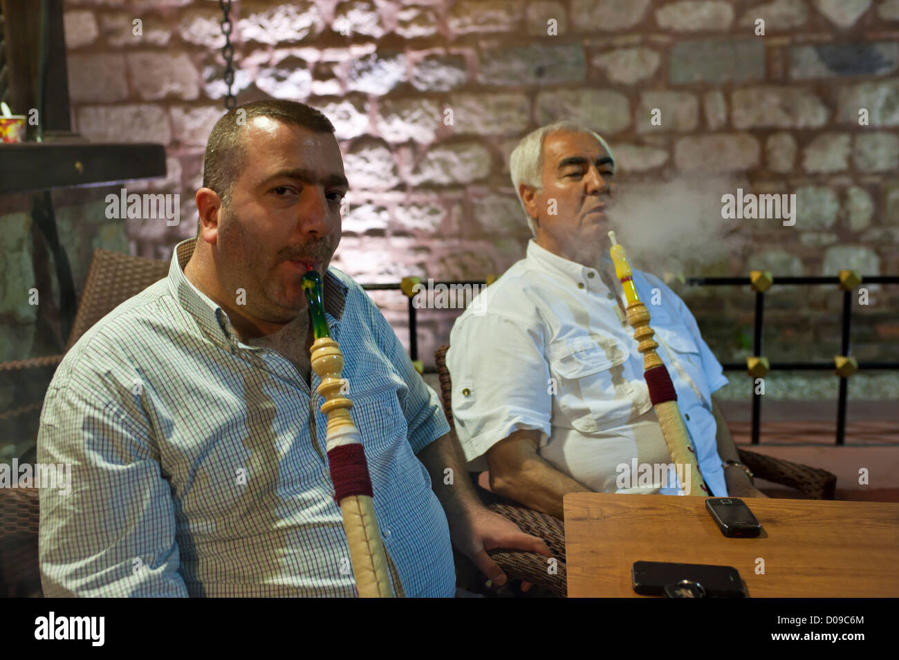 Two Turkish men smoking water pipes. Stock Photo