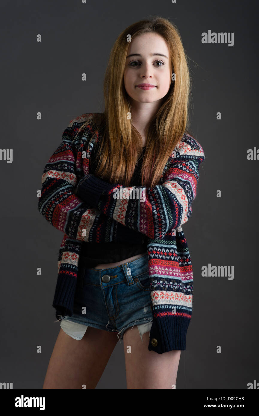 A 14 - 15 year old longh haired teenage girl, single, standing with her  arms crossed, wearing denim shorts uk Stock Photo - Alamy