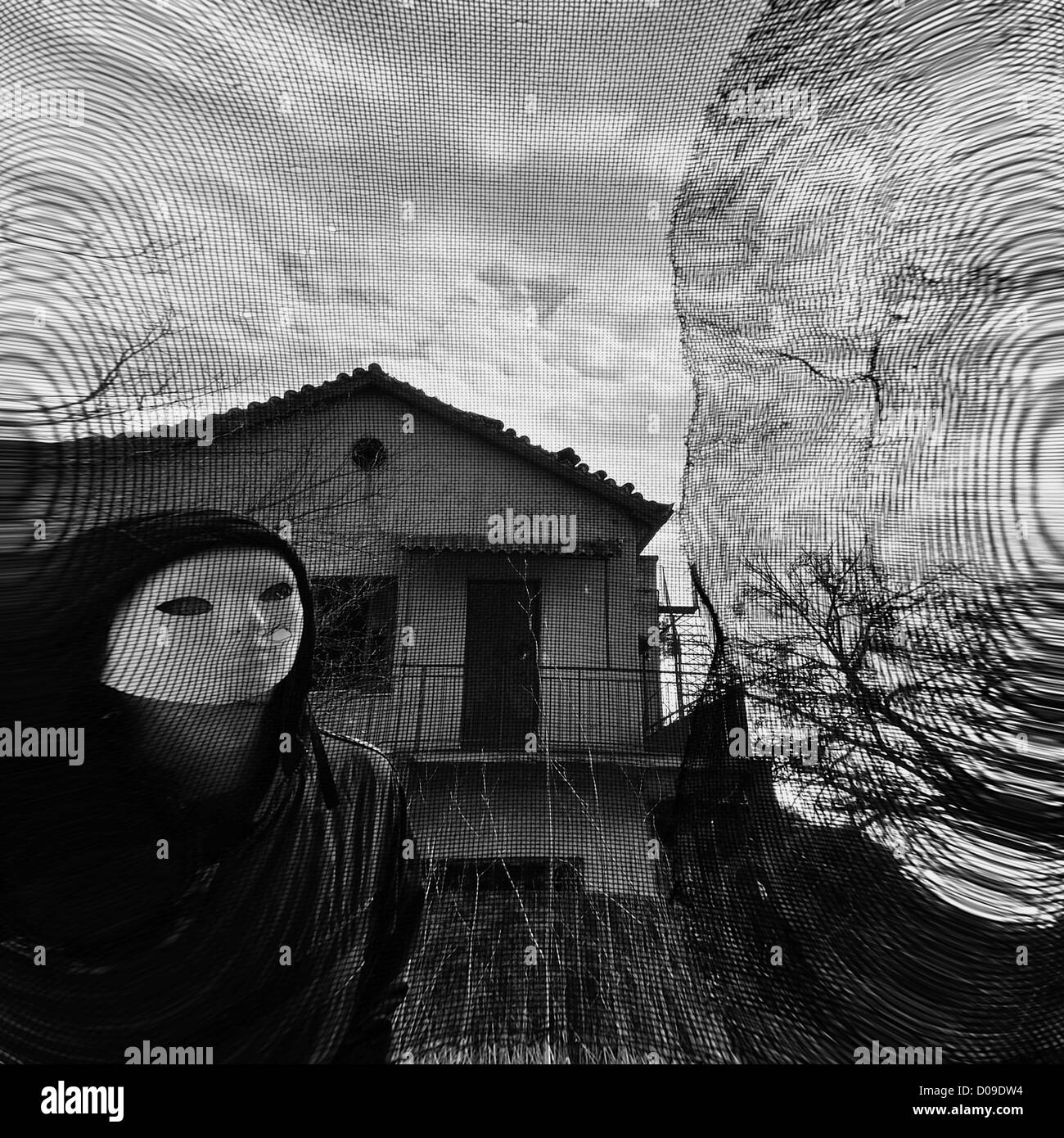 Masked figure behind threaded window. Black and white. Stock Photo