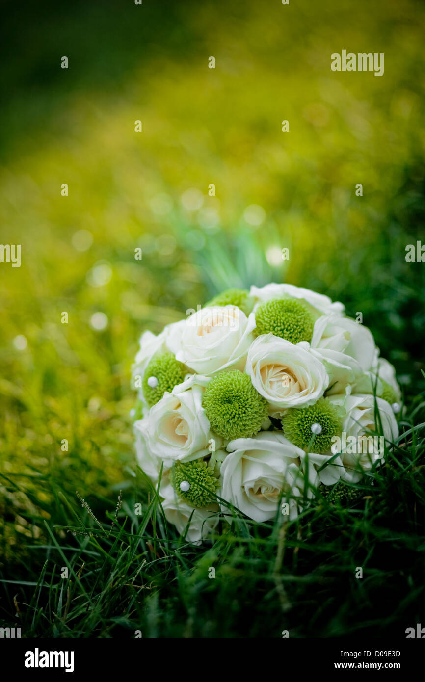 Wedding bouquet with white roses in fresh green grass Stock Photo