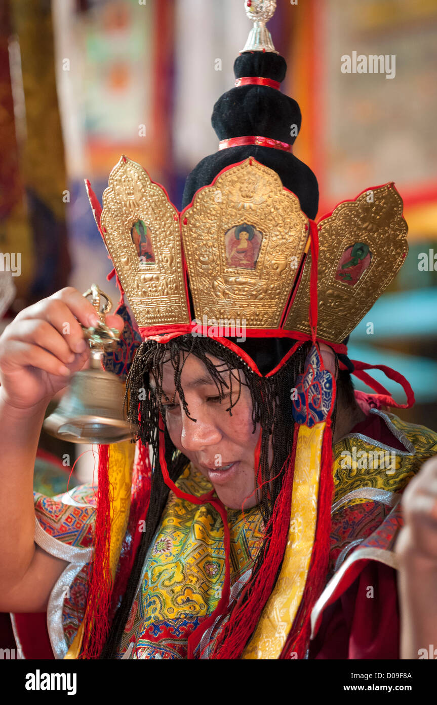 Wearing ceremonial head wear and vestments, Buddhist nuns ring bells