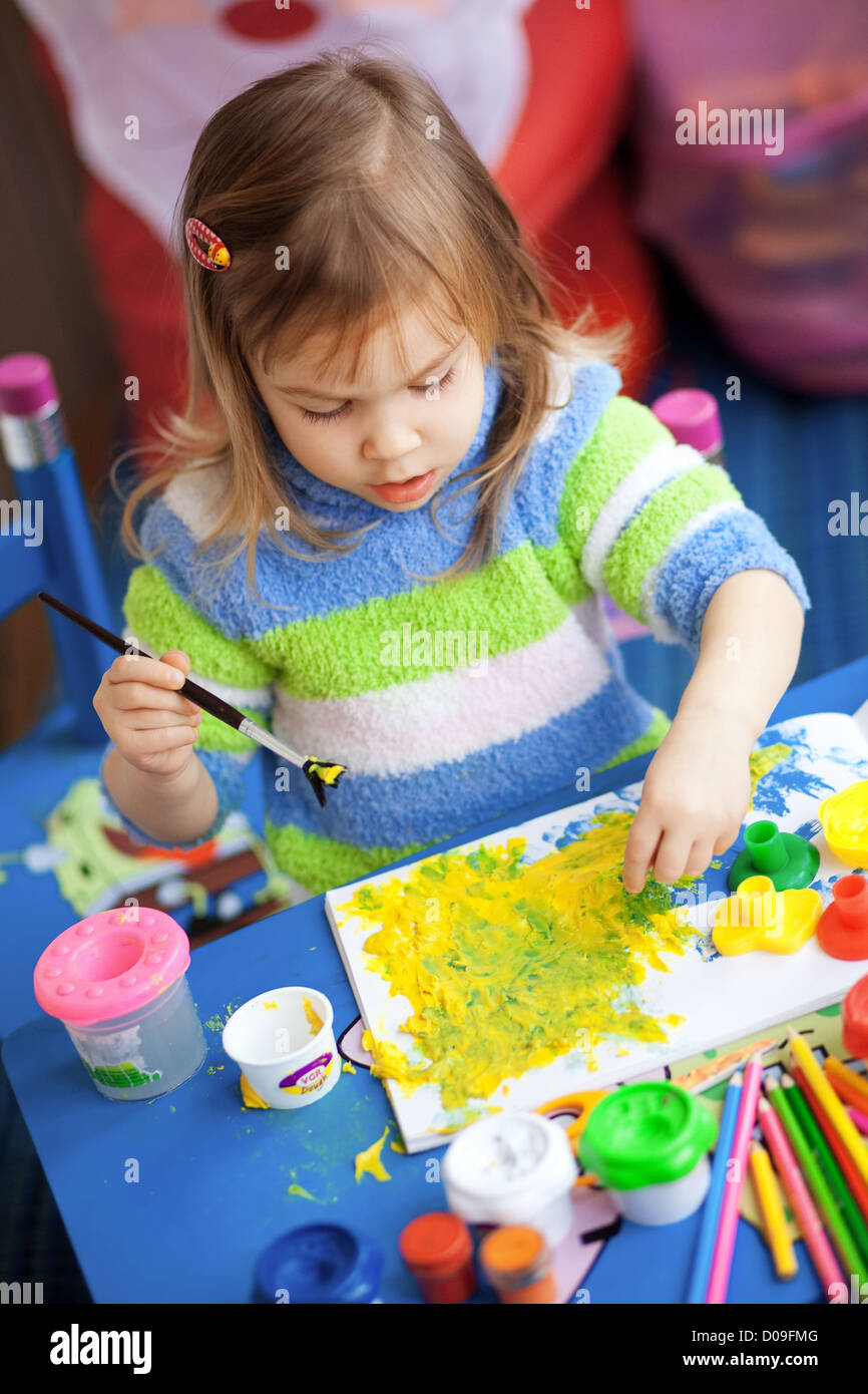 Little girl painting in her nursery at home Stock Photo - Alamy