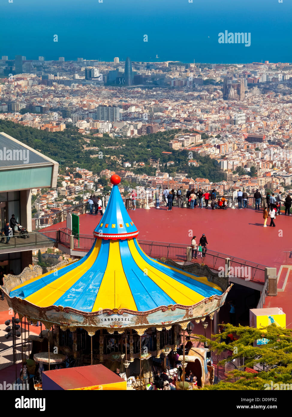 View over Tibidabo amusement park Barcelona Catalonia Spain showing carousel and view over city centre and the sea beyond Stock Photo
