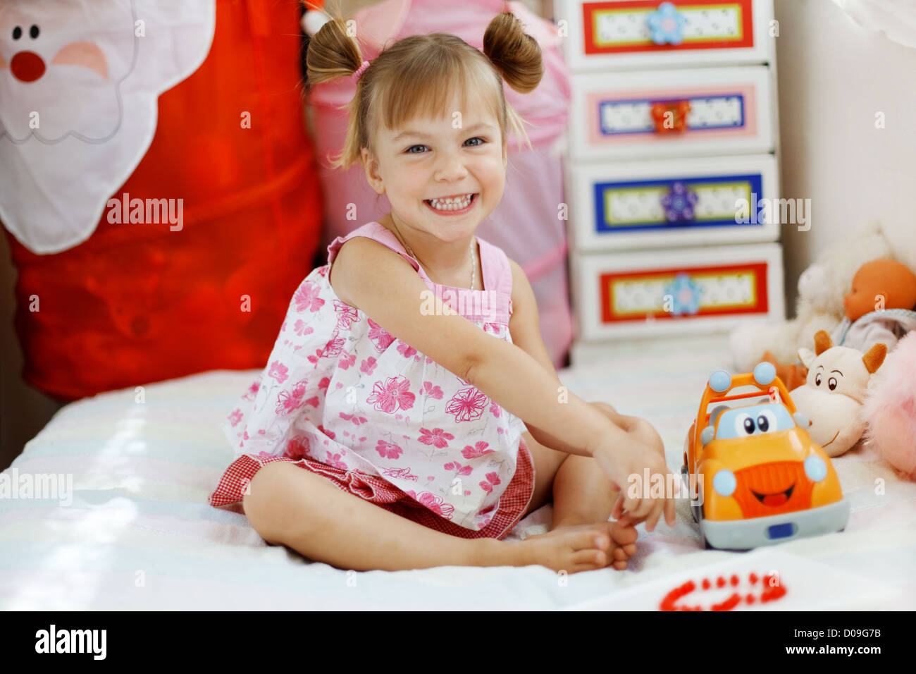 Little girl playing with toys in her nursery Stock Photo Alamy