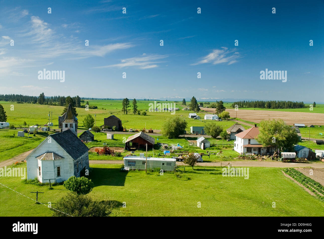 Church and houses in Flora, Oregon, with the Wallowa Mountains in the