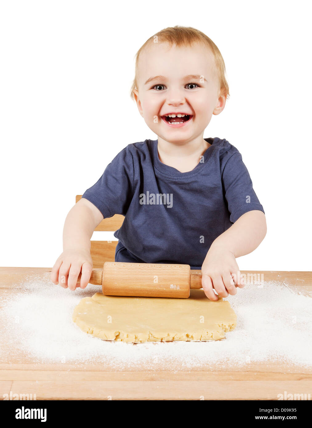 young child making cookies on small wooden desk Stock Photo