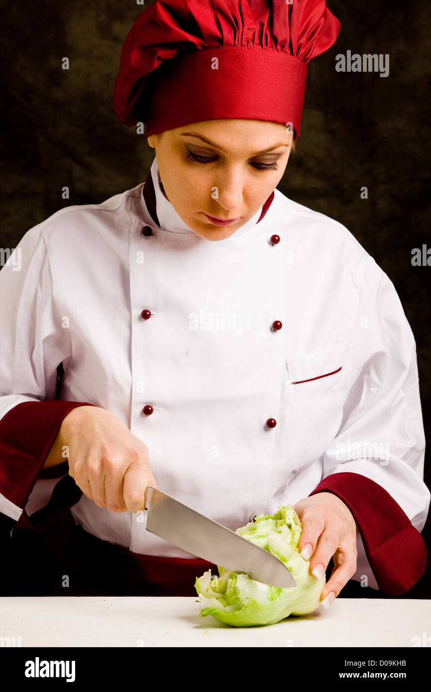 photo of young female chef cutting lettuce with knife Stock Photo Alamy