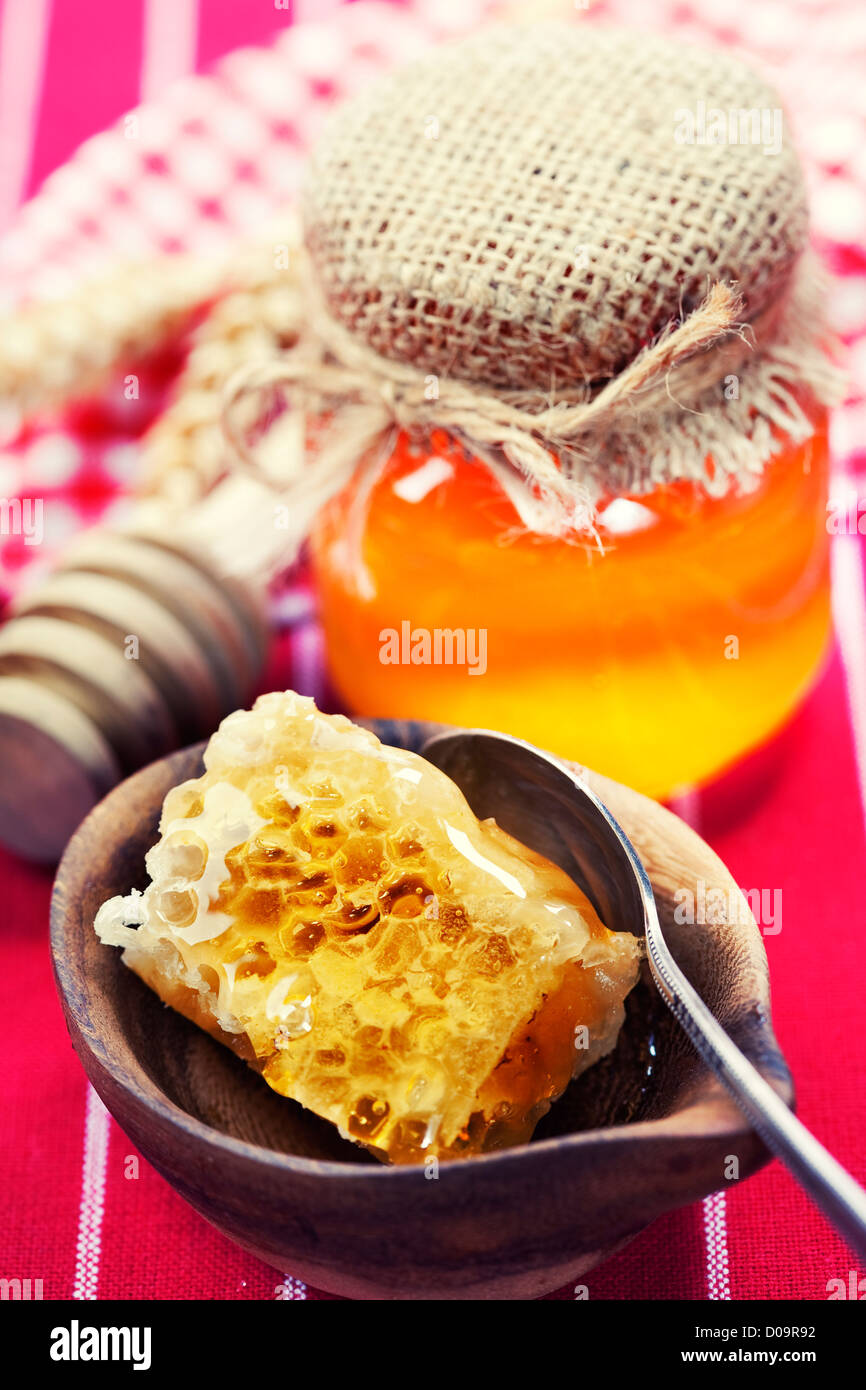 Beautiful comb, spoon and honey in jar Stock Photo - Alamy