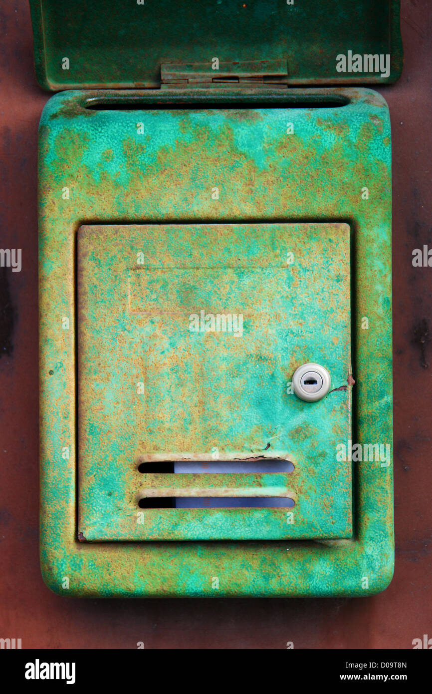 Old rusty mailbox on the shabby gate in Italy Stock Photo