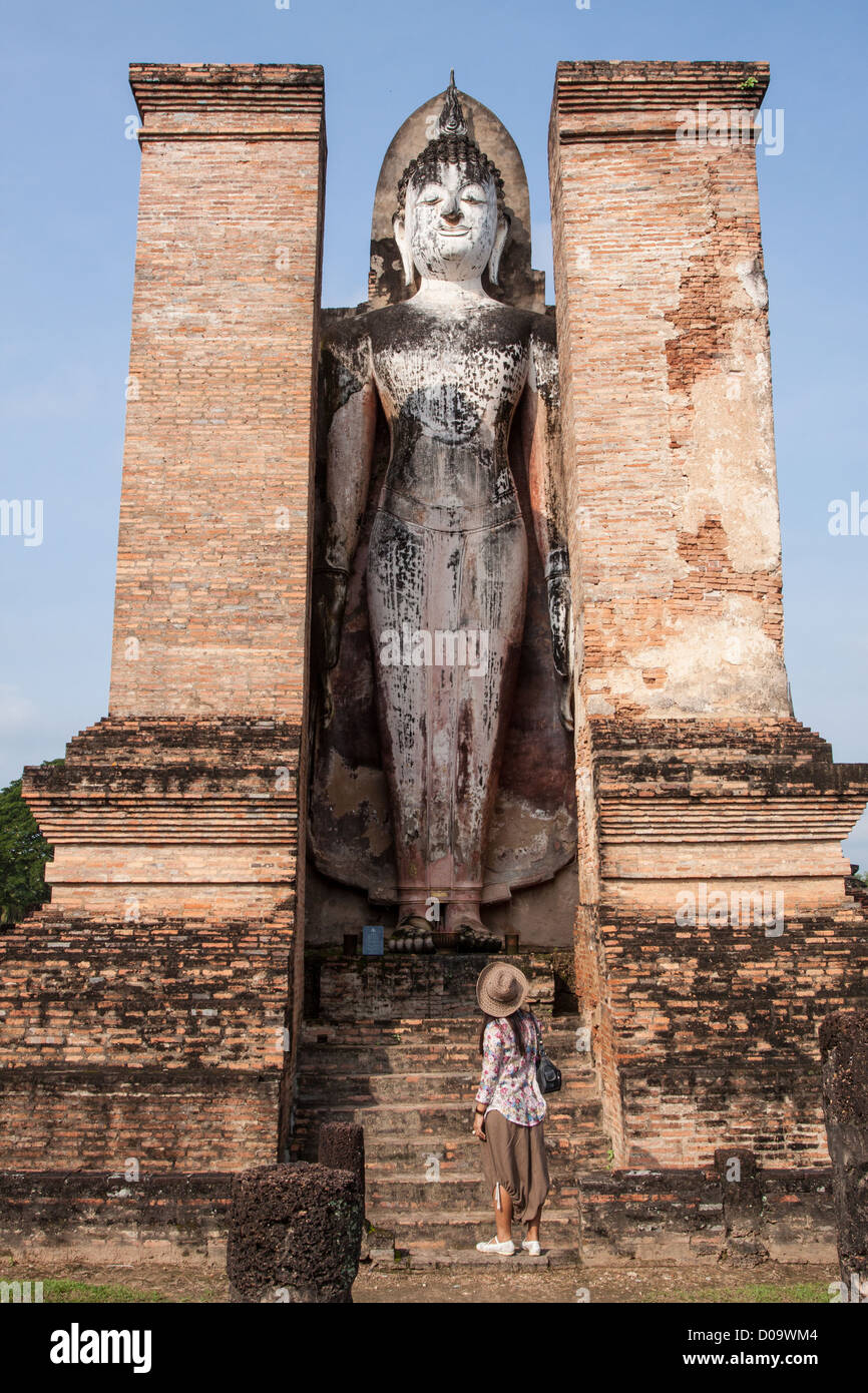 TOURISTS CONTEMPLATING STANDING BUDDHA IN HISTORICAL PARK SUKHOTHAI OLD CITY LISTED AS WORLD HERITAGE SITE UNESCO THAILAND ASIA Stock Photo