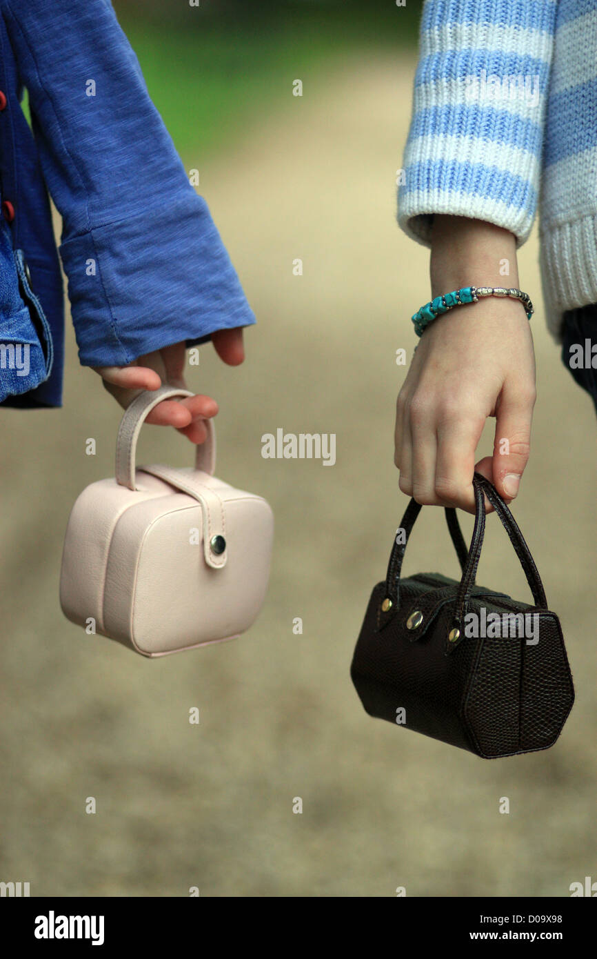 young girls hands holding small handbags Stock Photo