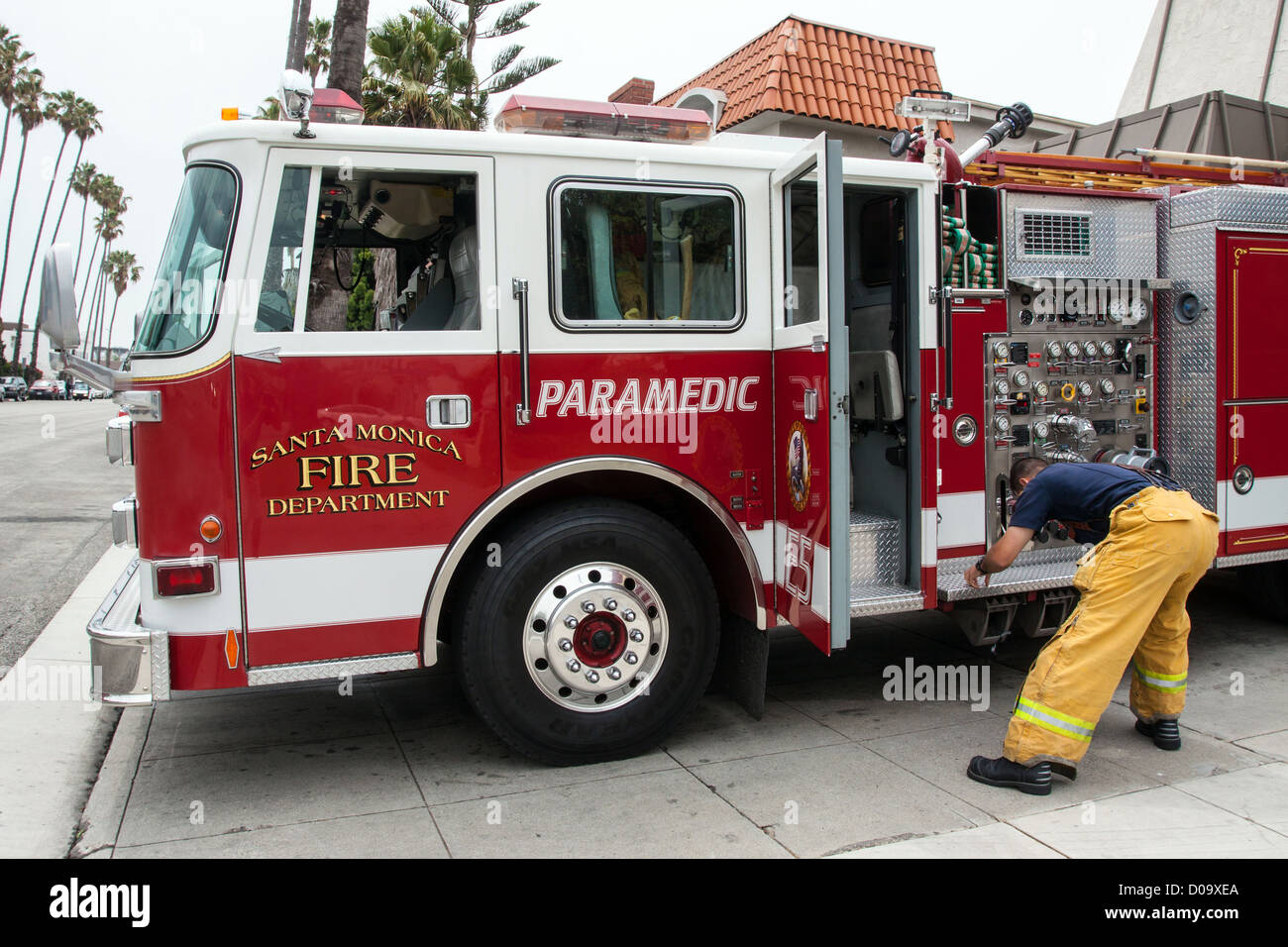 FIREFIGHTER PREPARING A FIRE ENGINE FOR A FIRE IN SANTA MONICA LOS ANGELES CALIFORNIA UNITED STATES USA Stock Photo