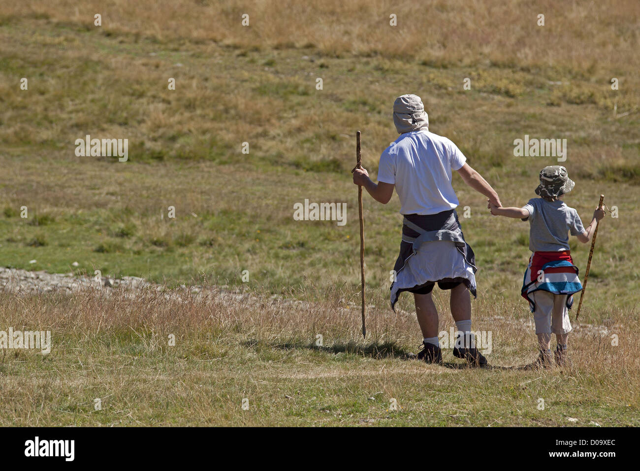 FATHER AND SON WALKING IN THE MOUNTAINS ON A HIKING TRAIL IN CHAMROUSSE ISERE RHONE-ALPES FRANCE Stock Photo