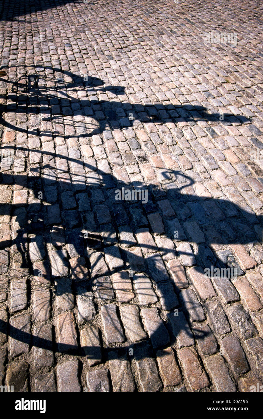 Cycling Couples shadow on Cobblestones Stock Photo