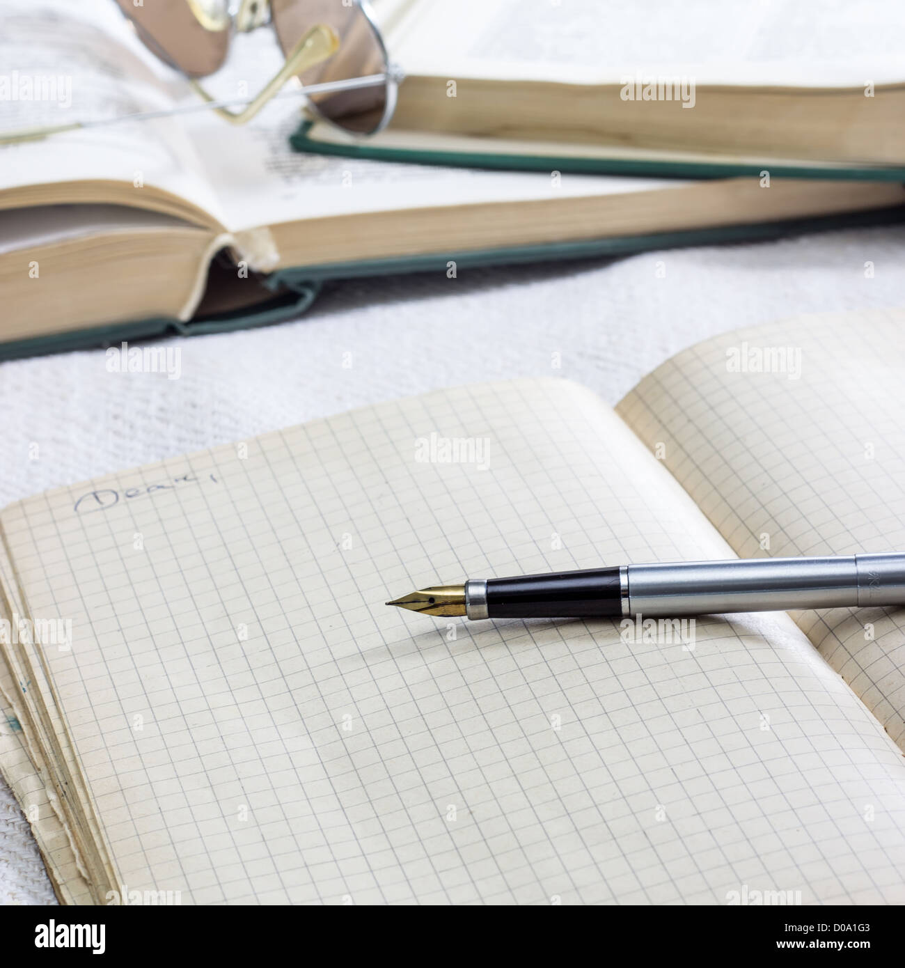 close up photo of notebook and books on table Stock Photo