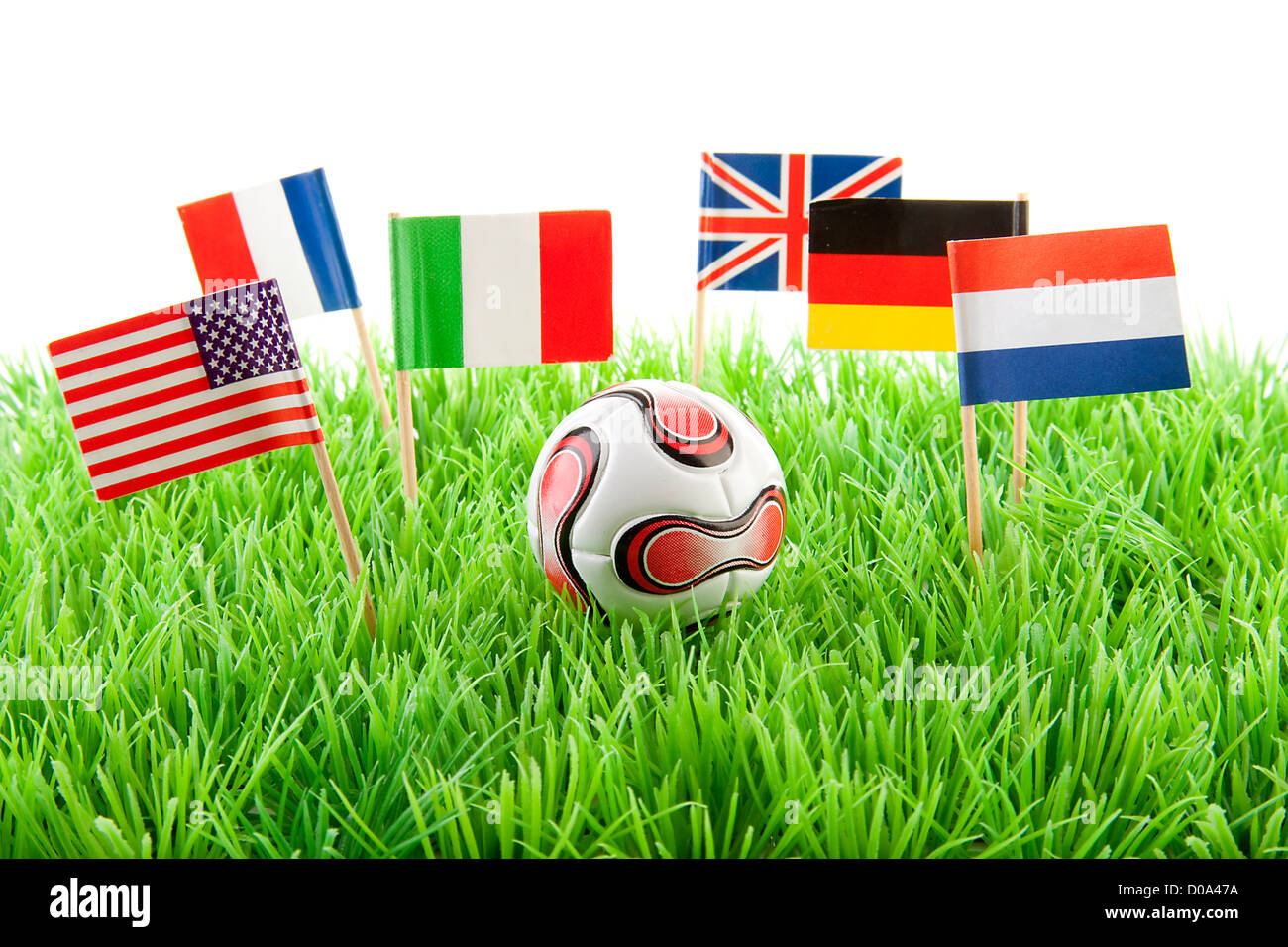 Flags and ball on soccer field over white background Stock Photo