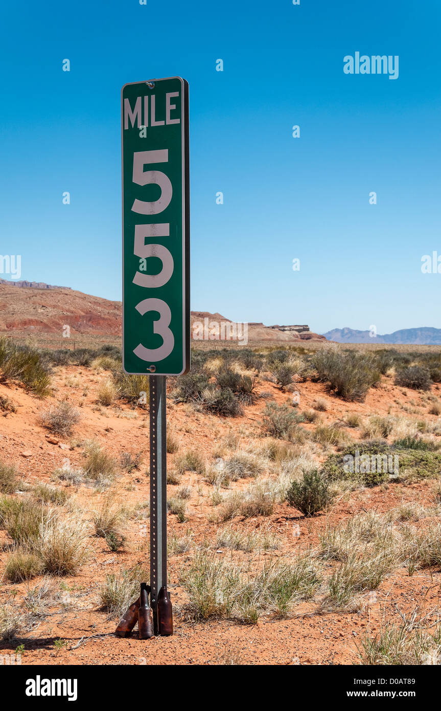 Beer bottles stacked neatly at base of milepost marker, US89A, Arizona