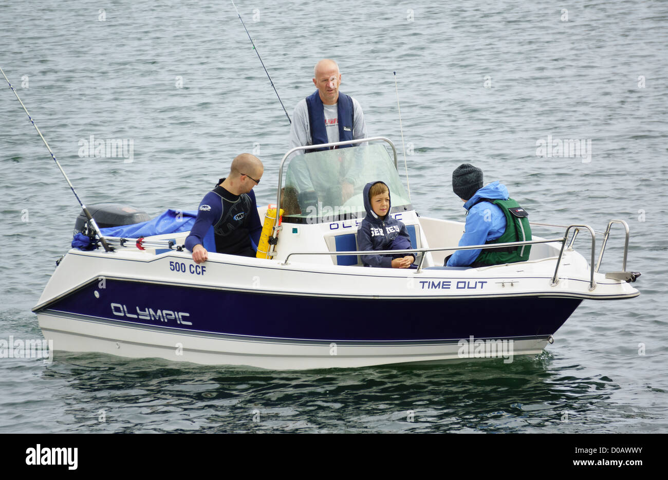 A family preparing for a fishing trip in a boat. Stock Photo