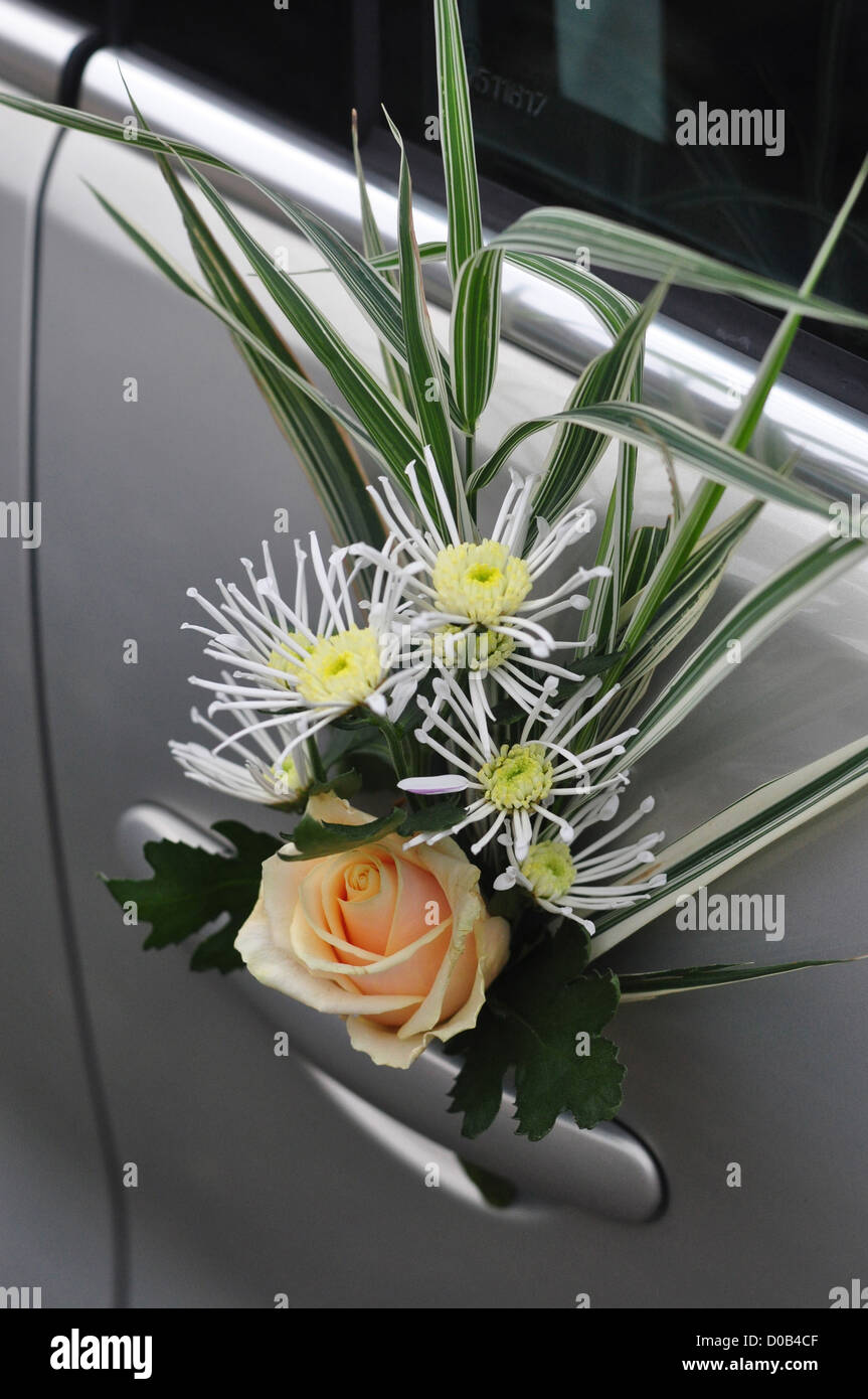 BOUQUET OF FLOWERS ATTACHED TO A CAR DOOR DECORATION FOR A WEDDING