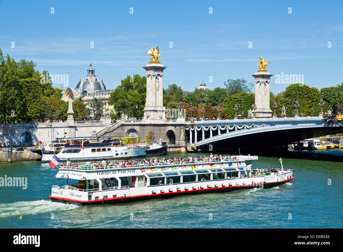 A bateaux mouches Tour boat full of tourists on the river Seine passing under the Pont Alexandre III Paris France EU Europe Stock Photo