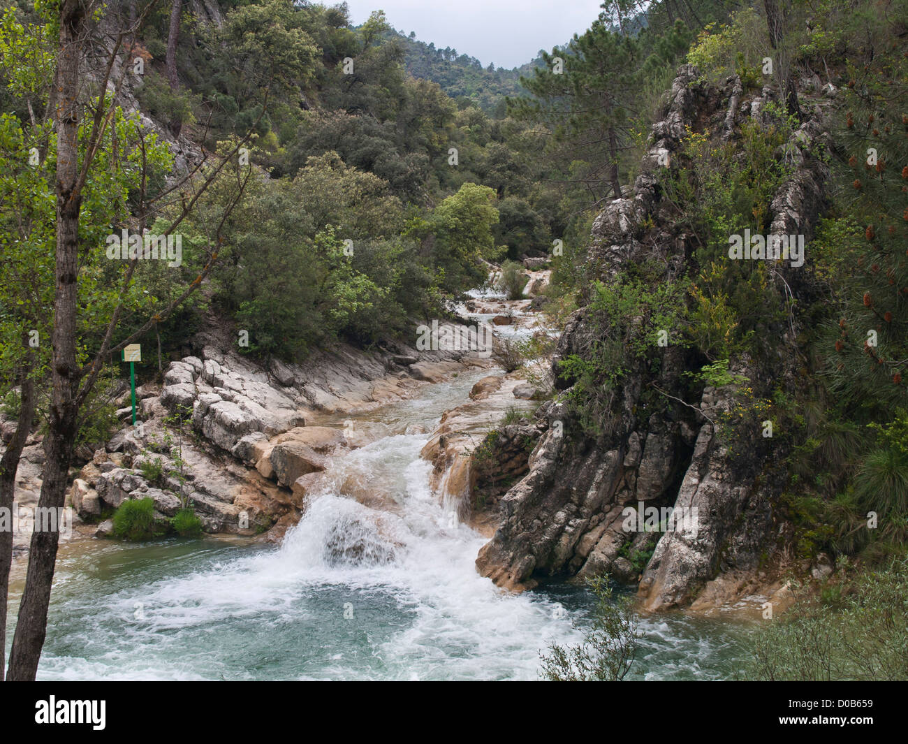 Hiking in Sierrra de Cazorla nature reserve in Andalusia Spain, view of waterfall over cliffs in the Rio Borosa river, signpost Stock Photo