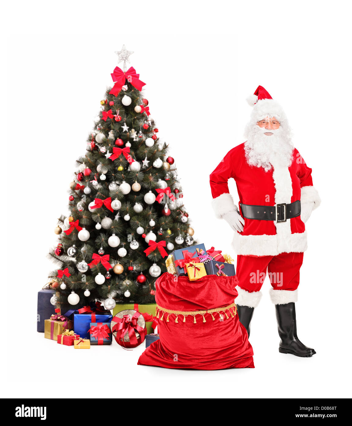 Full length portrait of a Santa Claus standing next to a Christmas tree ...