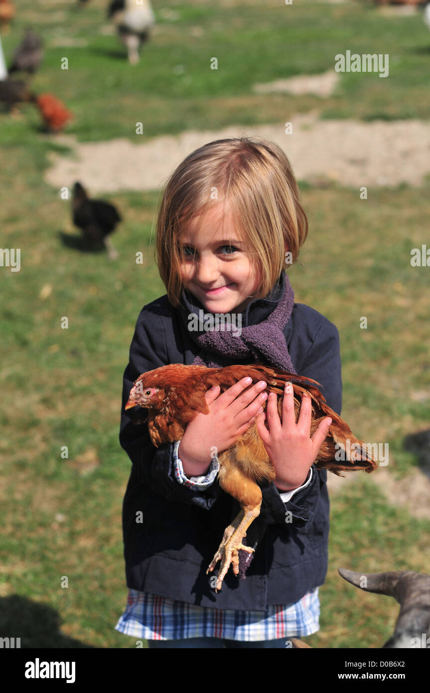 LITTLE GIRL CARRYING HEN DURING VISIT ASINERIE DU MARQUENTERRE FARM RAISING BOVINES POULTRY OTHER FARM ANIMALS QUEND SOMME (80) Stock Photo