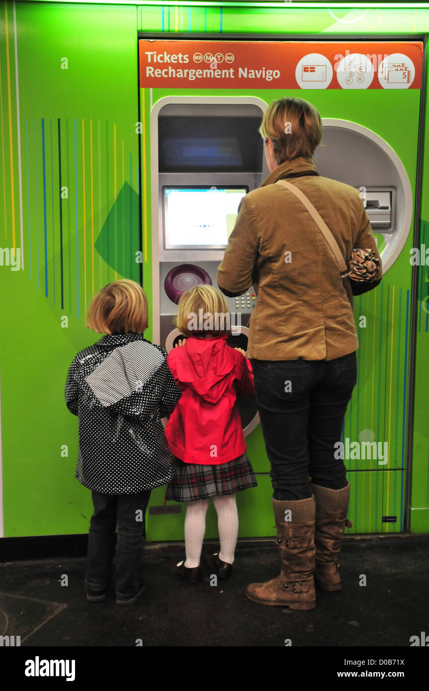 WOMAN AND HER CHILDREN BUYING METRO TICKETS FROM AN AUTOMATIC DISTRIBUTOR PARISIAN METRO STATION PARIS (75) FRANCE Stock Photo