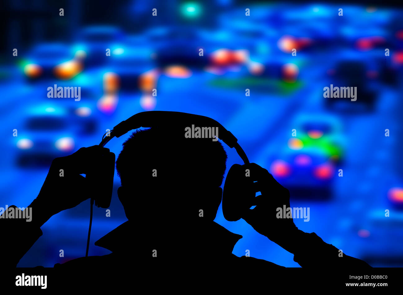 policeman monitoring heavy night road traffic from bridge Stock Photo