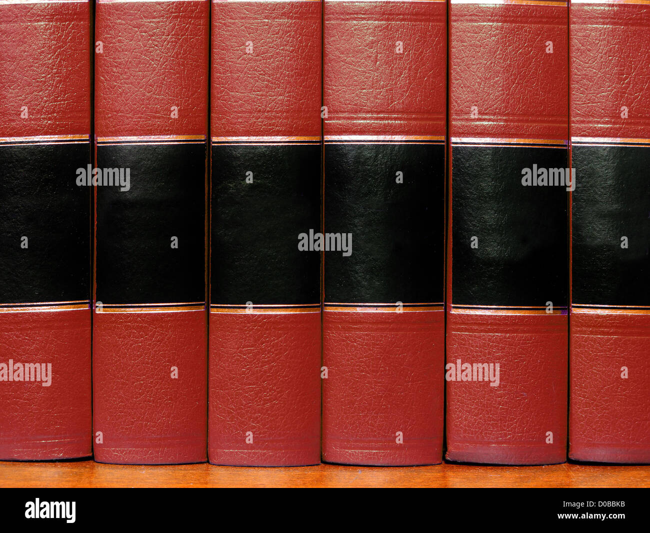 Row of old red leather books on a shelf with blank covers Stock Photo