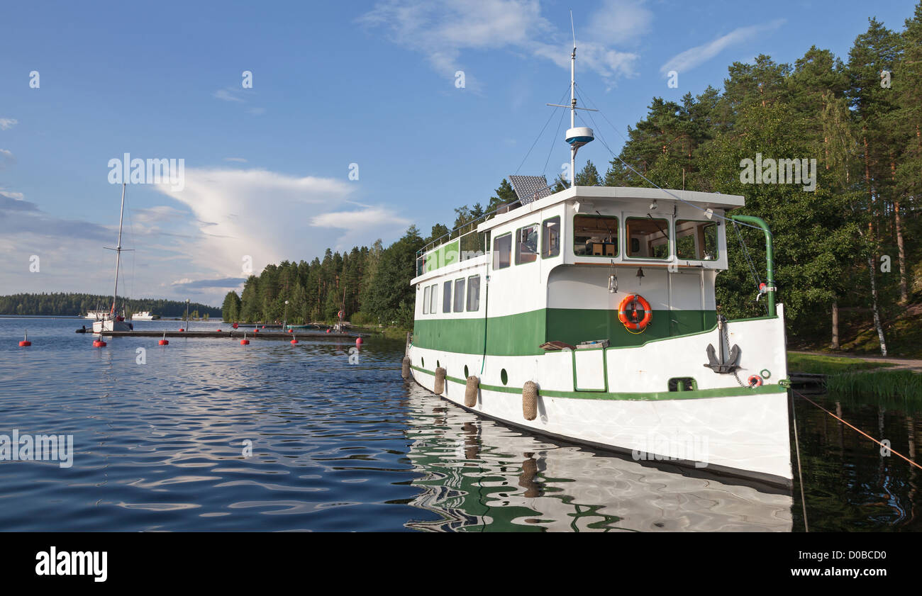 Small white pleasure boat moored on Saimaa lake in Finland Stock Photo