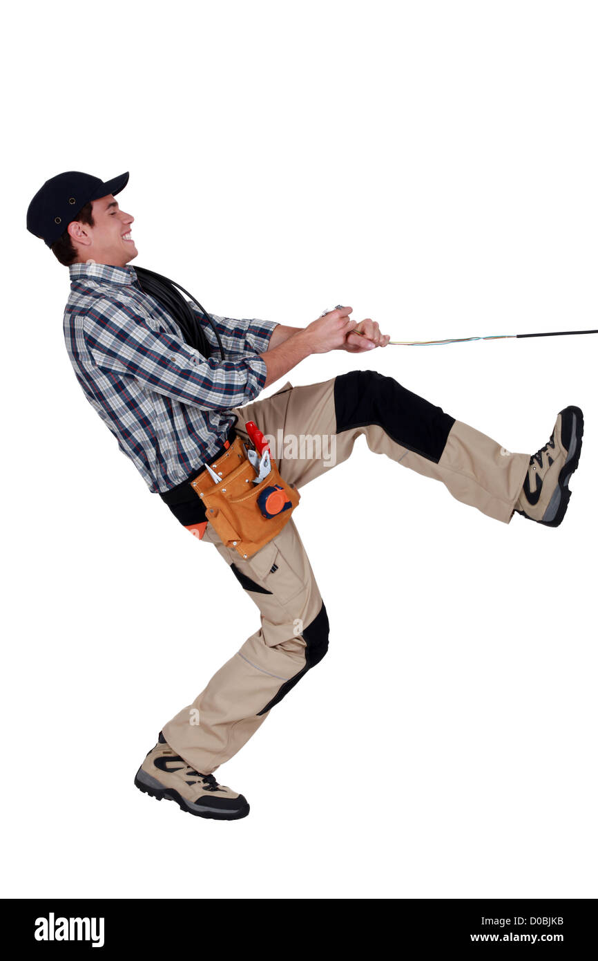 Handyman pulling a rope Stock Photo
