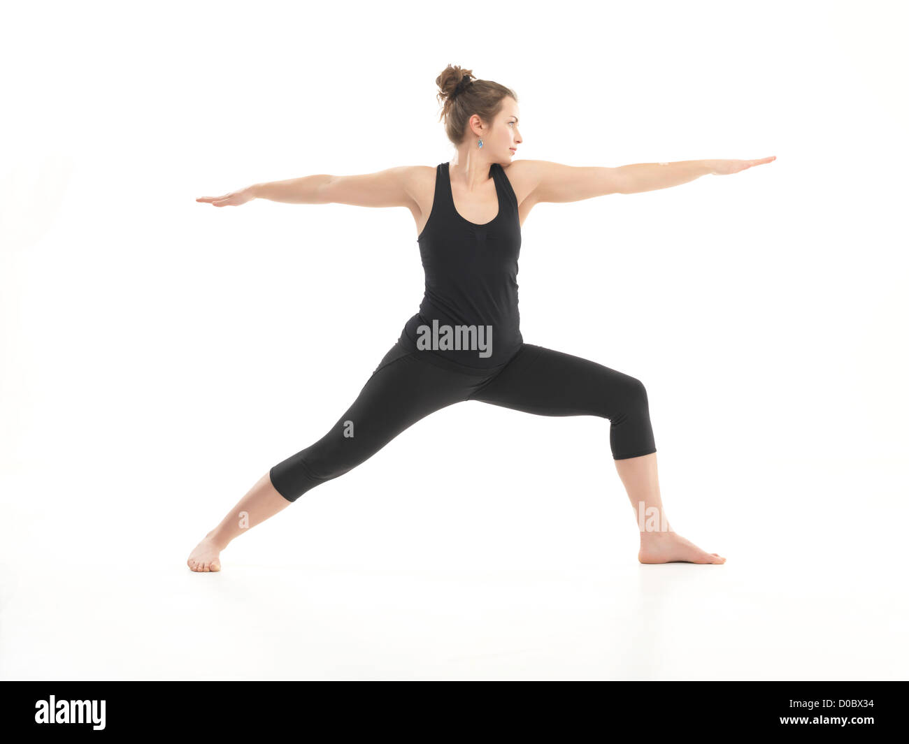 single young, woman in yoga pose, dressed in black on white background  Stock Photo