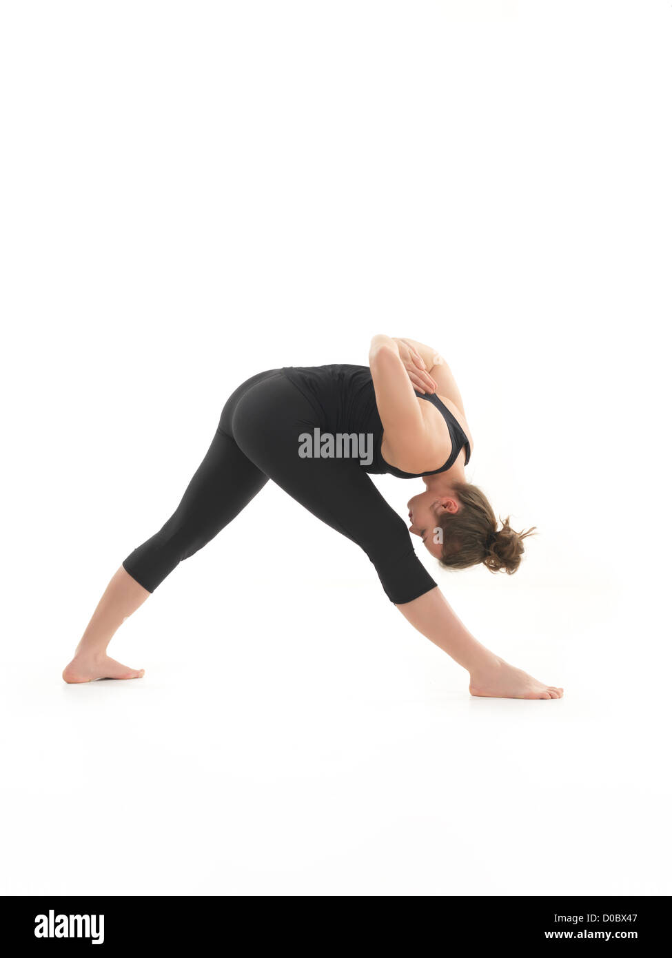 young, blonde woman practicing yoga posture, with face obscured, ressed in black, on white blackground Stock Photo