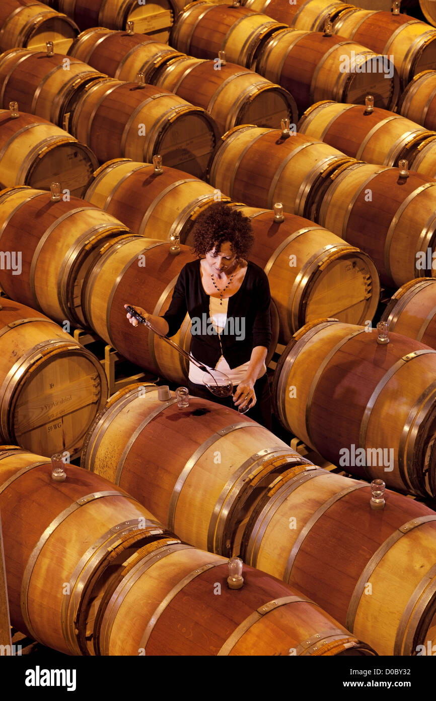 Winemaker Laura Sorge barrel tastes in the cellar. Stock Photo