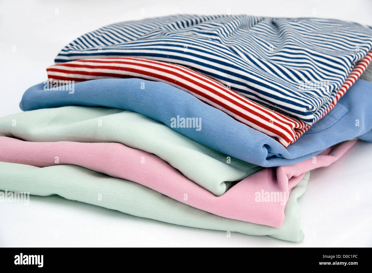 Pile of ladies jumpers / sweaters / tops isolated on a white background Stock Photo