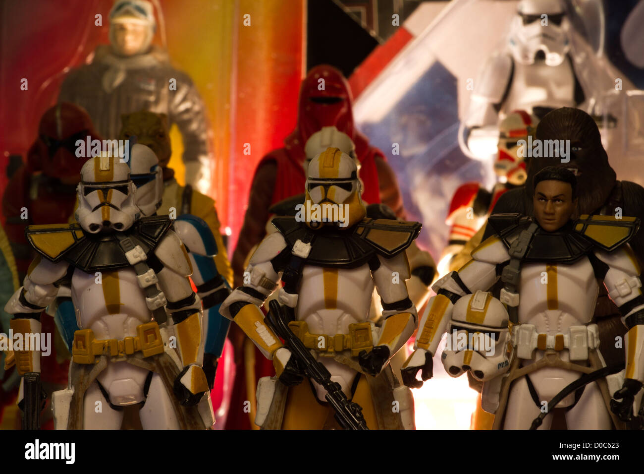 Various kinds of toys and figurines including characters from star wars stood up in a cabinet Stock Photo