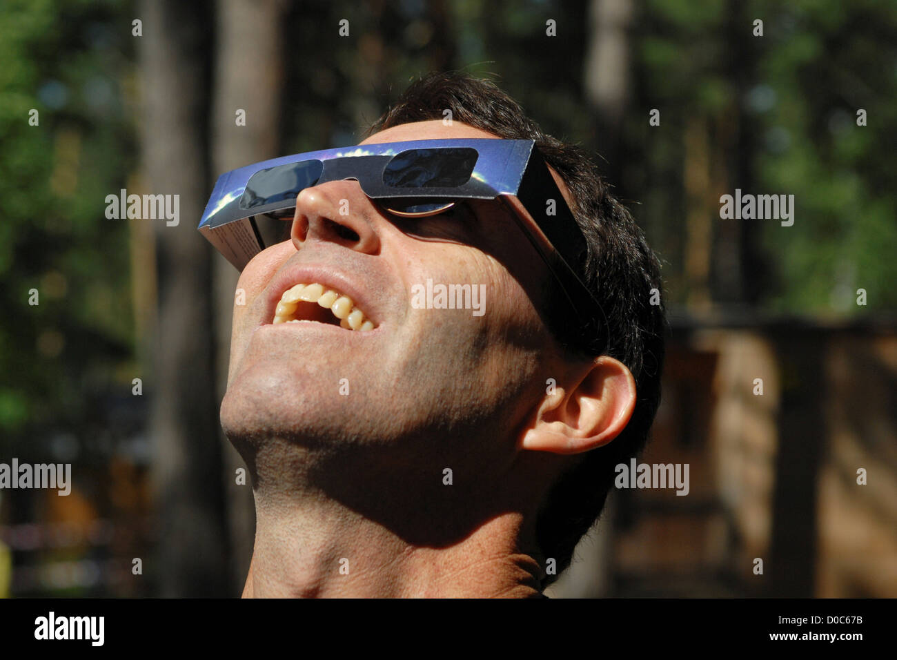 A spectator wearing protective glasses views total eclipse sun over Ob River near Novosibirsk Siberia Russia on August 1 2008. Stock Photo